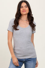 woman wearing a grey short sleeve scoop neck t-shirt paired with blue jeans