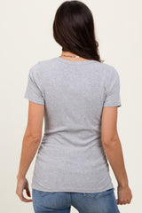 woman wearing a gray short sleeve t-shirt, viewed from the back, paired with blue jeans