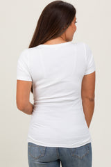 woman wearing a white short sleeve maternity top, viewed from the back, paired with blue jeans