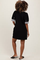 woman wearing a black maternity dress with striped short sleeves, standing with her back to the camera