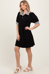 woman wearing a black short sleeve dress with striped collar and puff sleeves