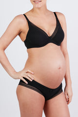 woman wearing a black maternity bra and matching briefs, showing her baby bump
