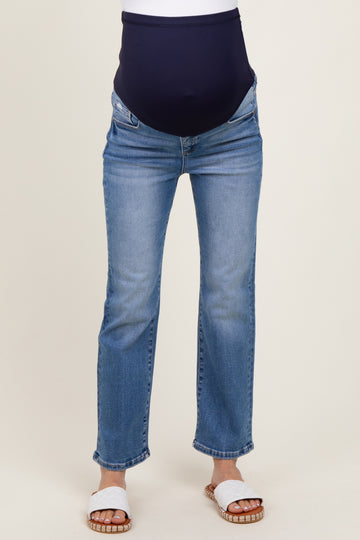 woman wearing light blue maternity jeans with a navy over-the-bump waistband and white sandals