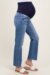 woman wearing a pair of light blue maternity jeans with a supportive navy waistband, highlighting her baby bump