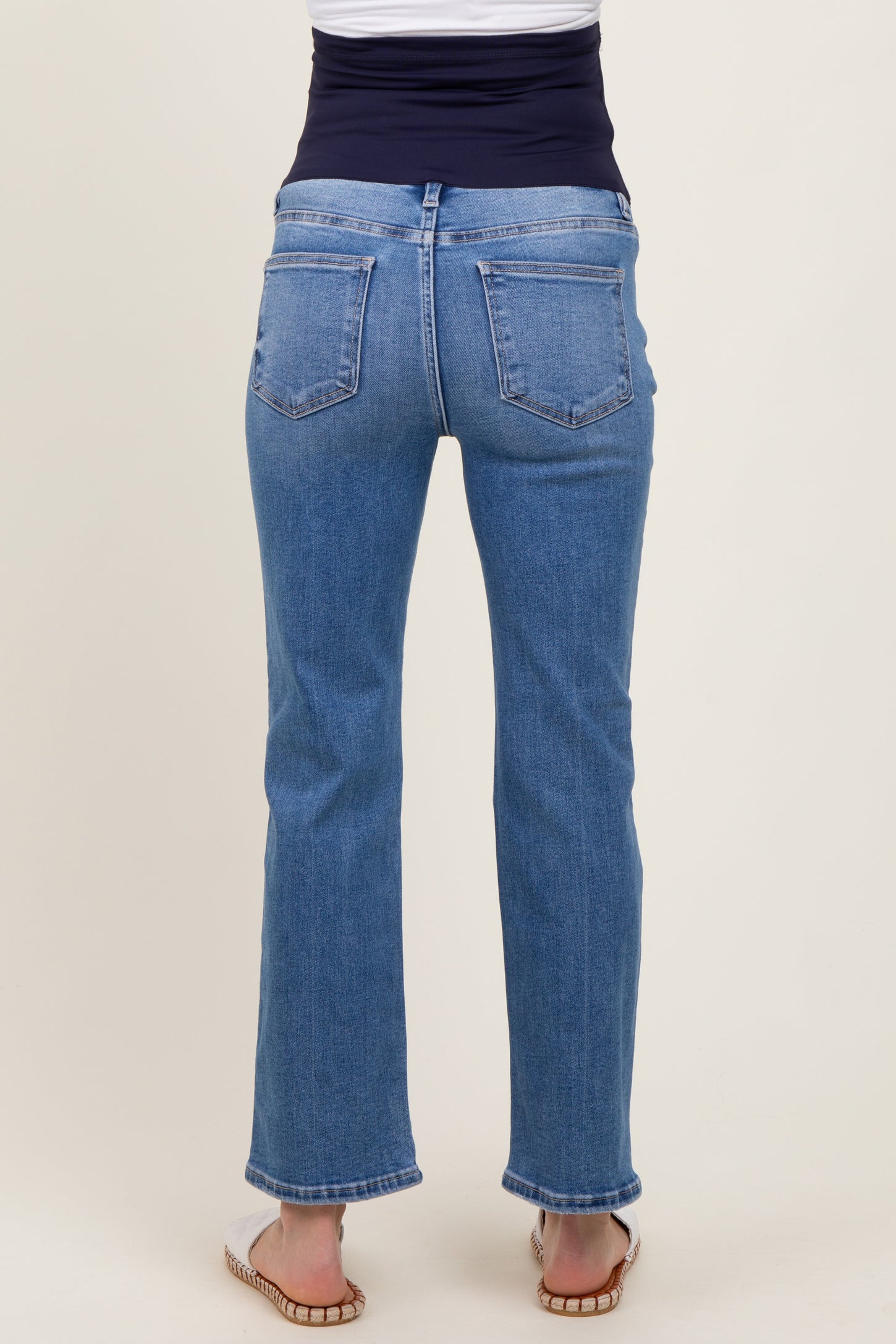 woman wearing maternity light blue straight leg jeans with a flexible waistband, viewed from the back