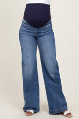 woman wearing blue maternity flared jeans with a navy supportive belly panel