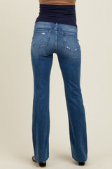 woman wearing a pair of blue bootcut maternity jeans, showing the back view with subtle distressing details