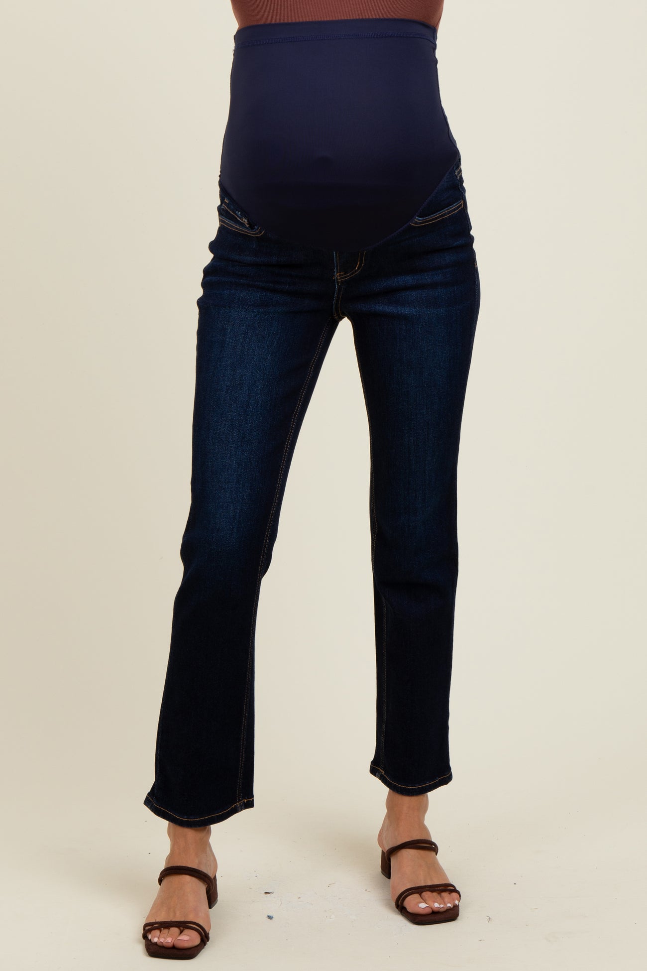 woman wearing dark blue maternity jeans with a high waistband and slight flare, showcasing a pregnant belly