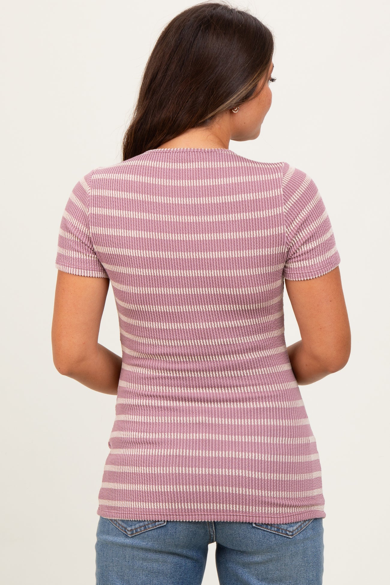 woman wearing a mauve and white striped maternity top, showing the back view with short sleeves and a fitted style