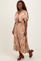 woman wearing a brown and white printed two-piece set with a cropped top and flowy pants