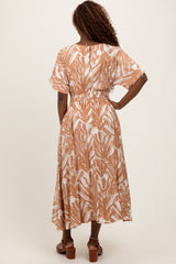 woman wearing a brown and white patterned maxi dress with short sleeves and an elastic waist, seen from the back