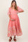woman wearing a pink floral maternity maxi dress and holding her baby bump