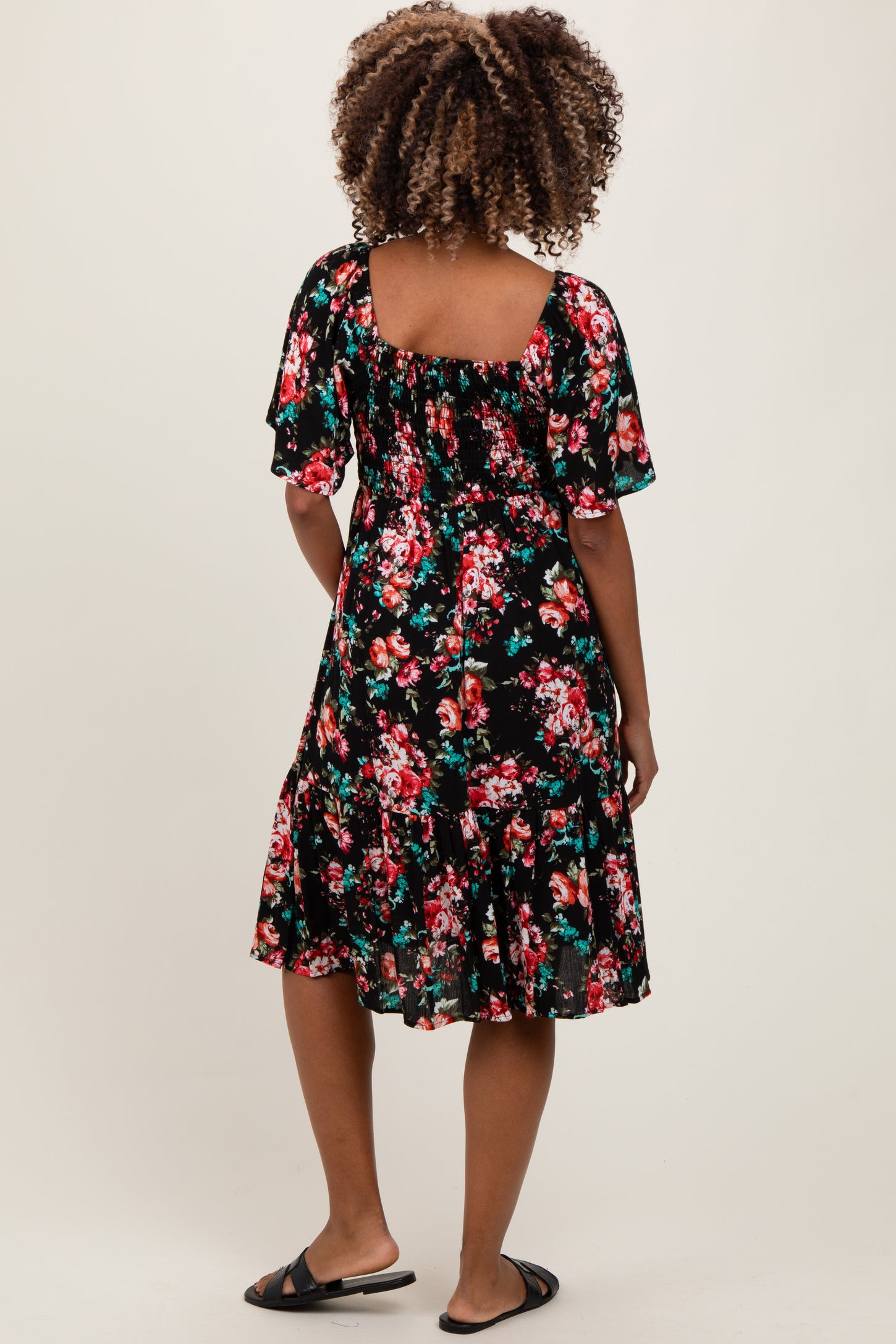 woman wearing a black floral maternity dress with short sleeves and a flared hem