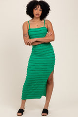 woman wearing a green striped midi dress with a thigh-high slit and spaghetti straps