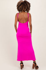 woman wearing a bright pink maternity maxi dress with a low back design