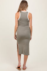 woman wearing a fitted olive green maternity dress with white trim and side slits, seen from the back