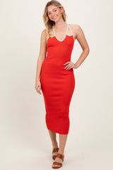 woman wearing a red ribbed midi dress with a halter neckline and beige straps, smiling and posing for the photo