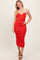 woman wearing a red ribbed midi dress with a halter neckline and beige straps, smiling and posing for the photo