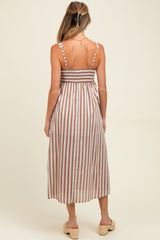 woman wearing a striped maternity maxi dress with smocked bodice and spaghetti straps, showcasing a baby bump