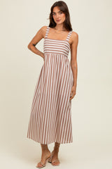 woman wearing a brown and white striped midi dress with wide straps and a fitted bodice