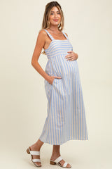 woman wearing a blue and white striped maternity dress with pockets, holding her baby bump