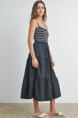 woman wearing a black and white striped tiered maxi dress with spaghetti straps and sandals