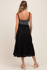 woman wearing a black and white striped maternity dress with a tiered skirt and back view visible