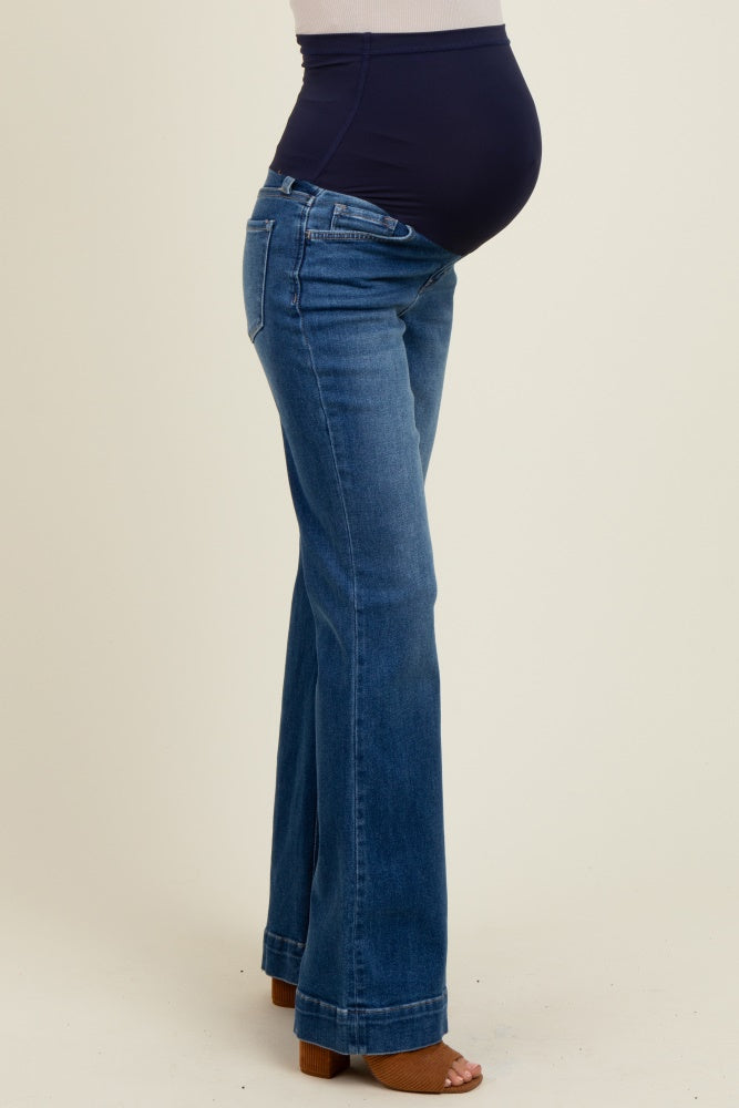 woman wearing dark blue maternity jeans with a supportive belly panel and a visible baby bump