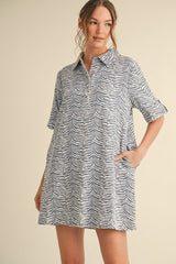 woman wearing a short-sleeve blue and white striped shirt dress with a collar and side pockets