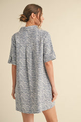 woman wearing a short-sleeve blue and white zebra print dress, viewed from the back