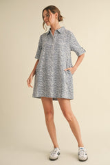 woman wearing a short-sleeve zebra print shirt dress with a collar and pockets, styled with white sneakers