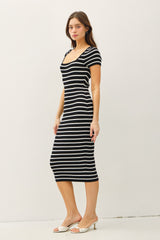 woman wearing a black and white striped midi dress with short sleeves and a square neckline
