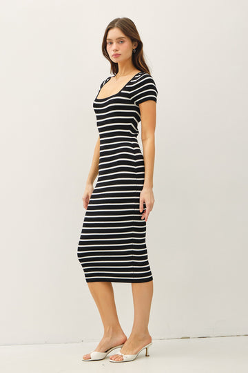 woman wearing a black and white striped midi dress with short sleeves and a square neckline