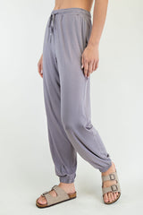 woman wearing light purple loose-fit jogger pants with an elastic waistband and cuffed ankles, paired with sandals