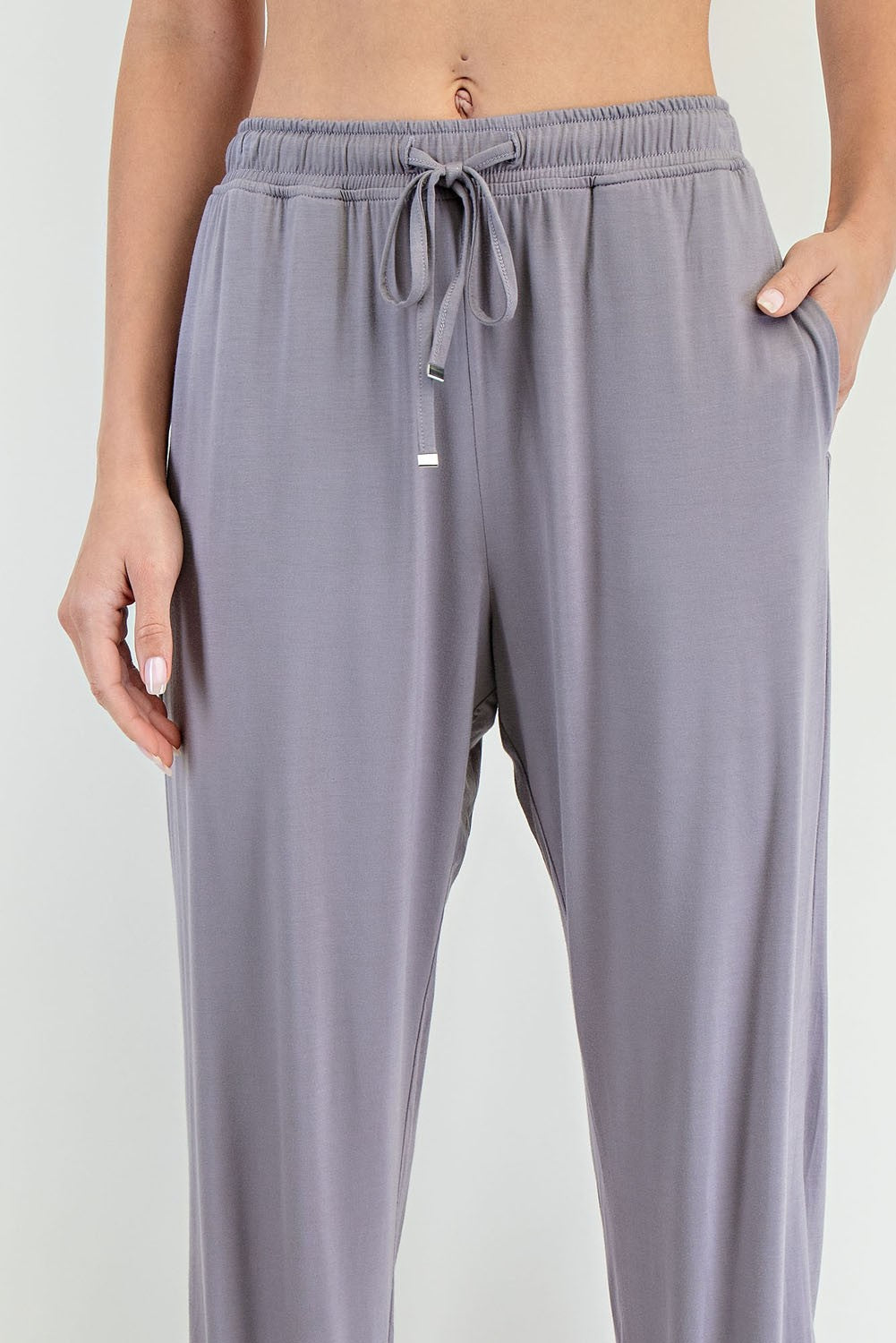 woman wearing light gray lounge pants with an elastic waistband and side pockets
