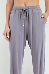 woman wearing light gray lounge pants with an elastic waistband and side pockets