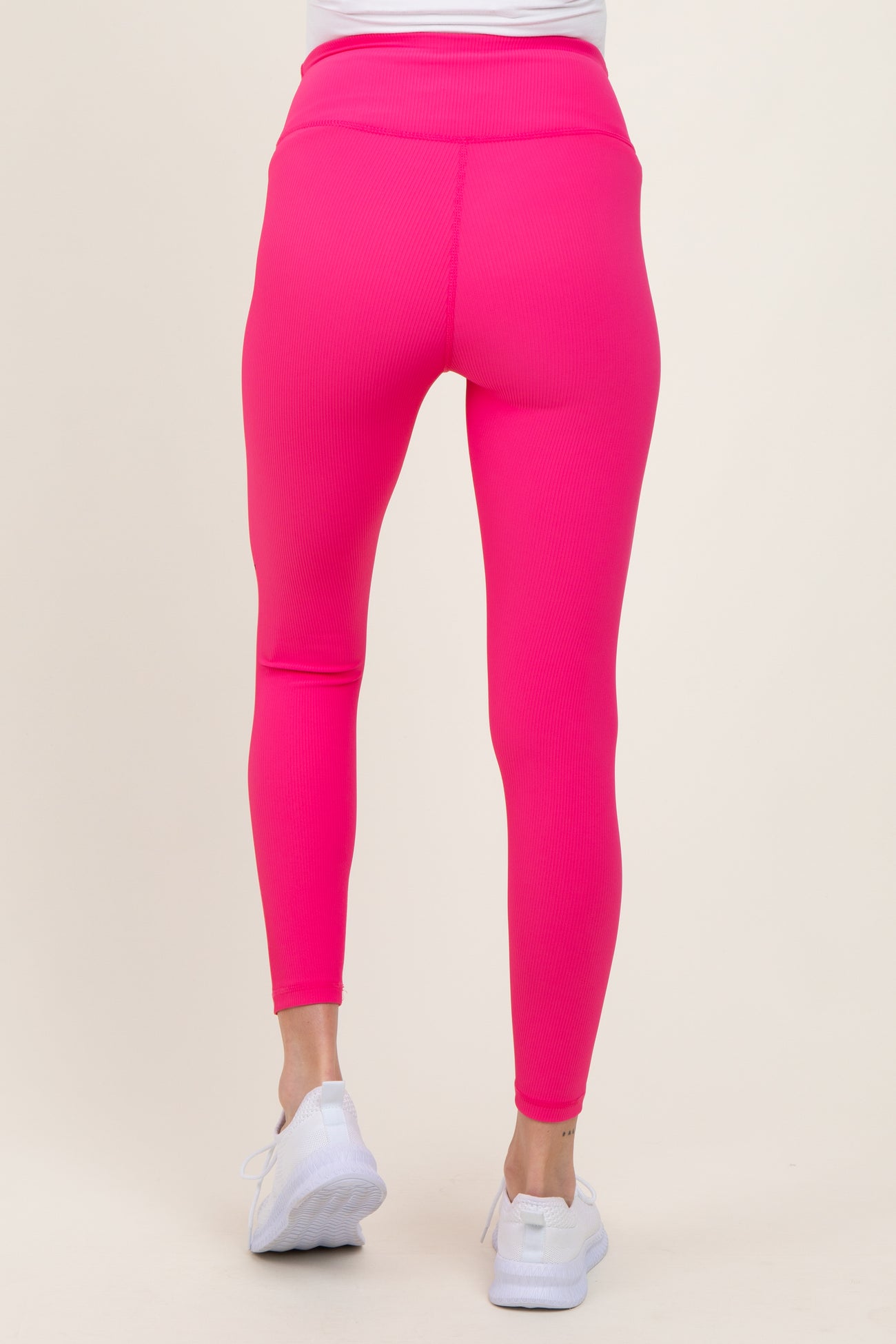 woman wearing bright pink maternity leggings, view from the back