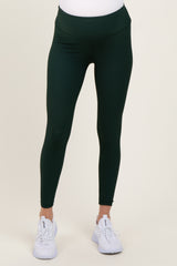 woman wearing dark green maternity active leggings with a high waistband and a fitted style