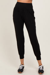 woman wearing black jogger pants with a wide waistband and side pockets