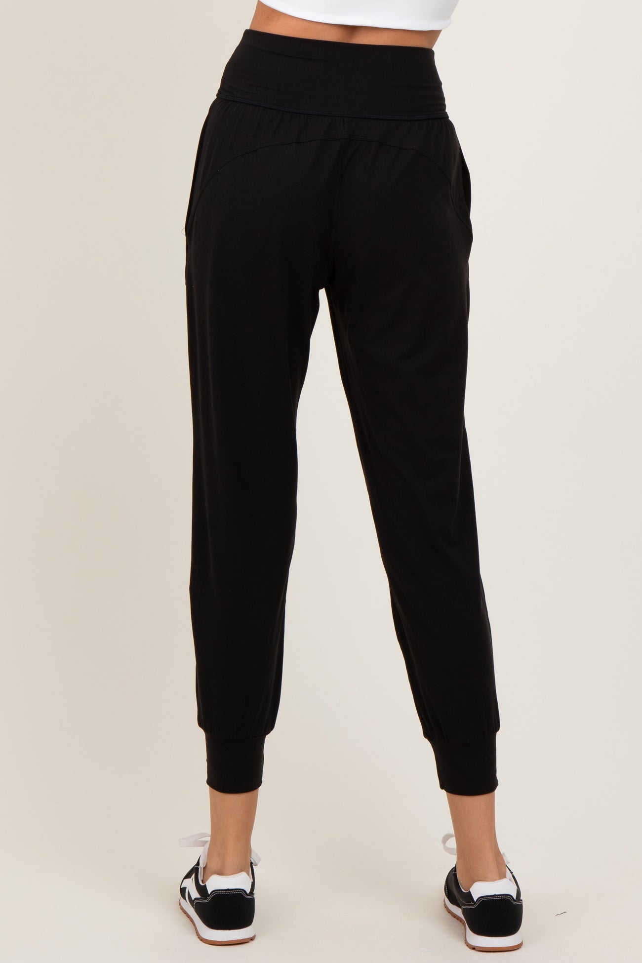 woman wearing black jogger pants with a relaxed fit and cuffed ankles, viewed from the back