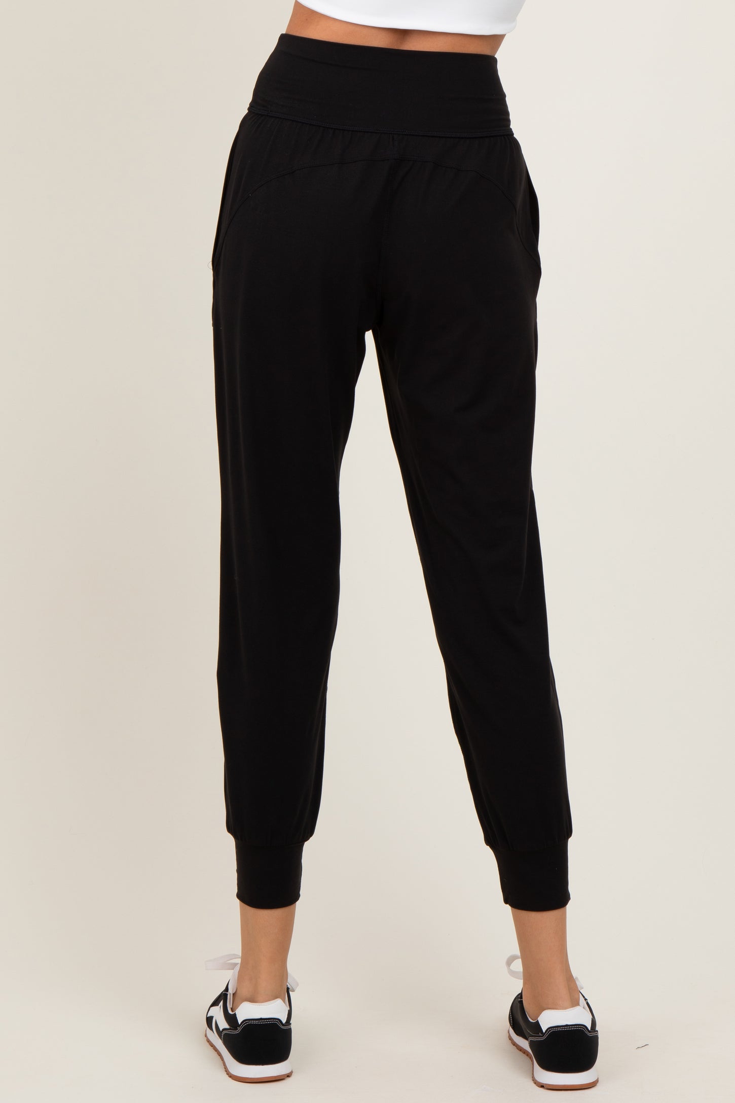 woman wearing black jogger pants with a relaxed fit and cuffed ankles, viewed from the back