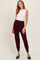 woman wearing a fitted white sleeveless top and burgundy jogger pants with elastic cuffs and waistband