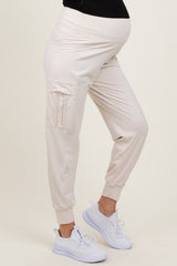 woman wearing light beige maternity joggers with pockets and a comfortable waistband