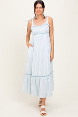 woman wearing a light blue striped maxi dress with tie straps and side pockets