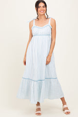 woman wearing a light blue striped maxi dress with ruffled straps and tiered hem