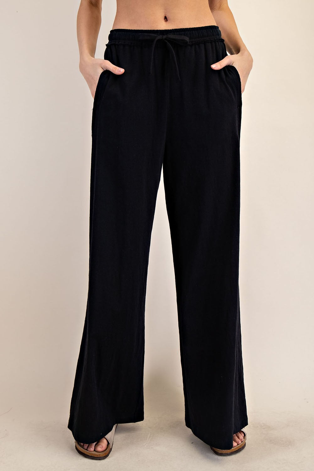 woman wearing black wide-leg pants with an elastic waistband and pockets