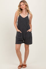 woman wearing a black striped sleeveless romper with pockets and a relaxed fit