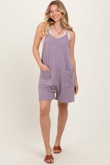woman wearing a purple striped sleeveless romper with side pockets and a relaxed fit
