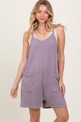 woman wearing a lavender knit romper with two front pockets and adjustable straps