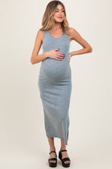woman wearing a light blue ribbed maternity dress and holding her baby bump